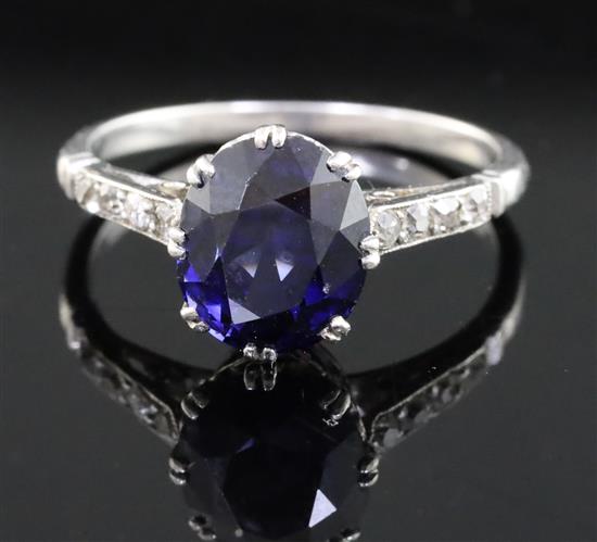 A mid 20th century platinum? and single stone oval synthetic sapphire ring, size M.